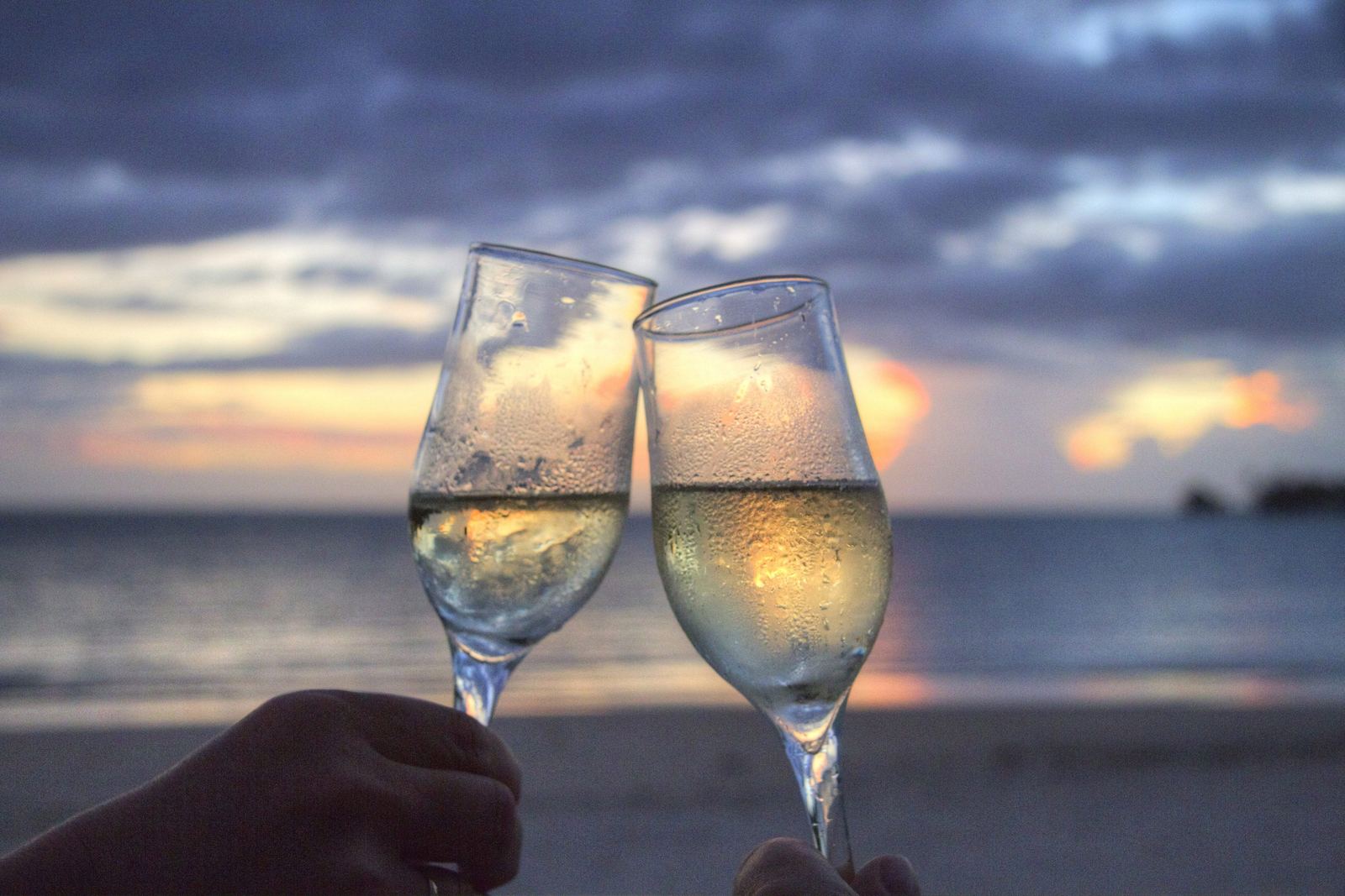 Glasses of prosecco at sunset over the sea